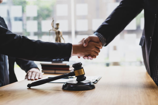 attorneys shaking hands at a legal video settlement meeting